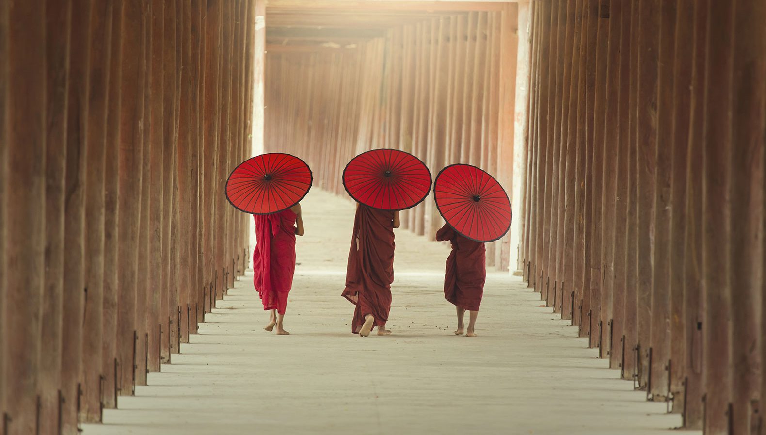 Drei junge buddhistische Mönche gehen einen Weg entlang
